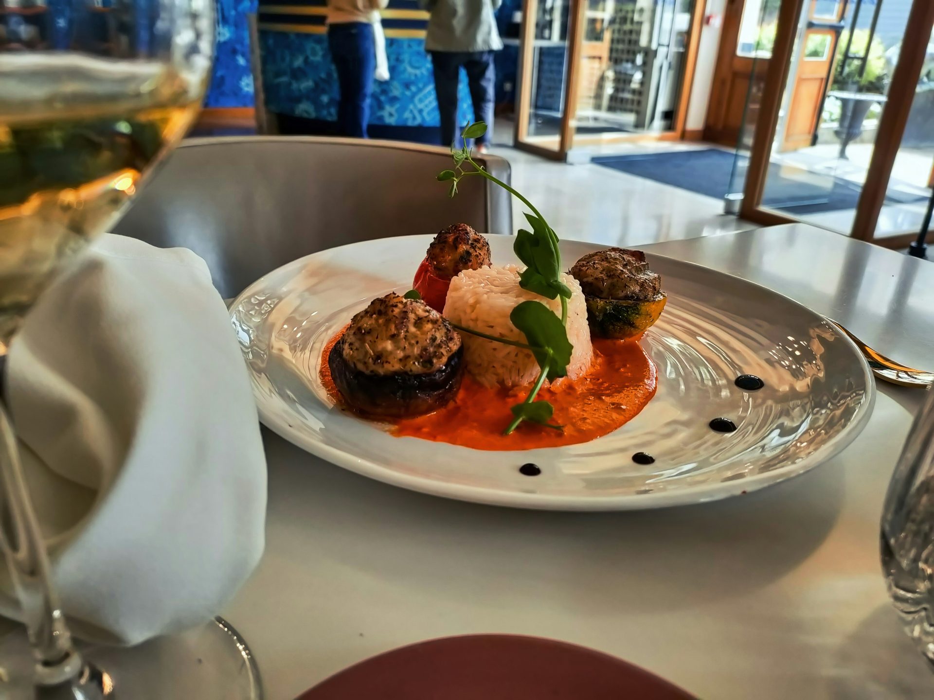 A plate of food and a glass of wine on a table